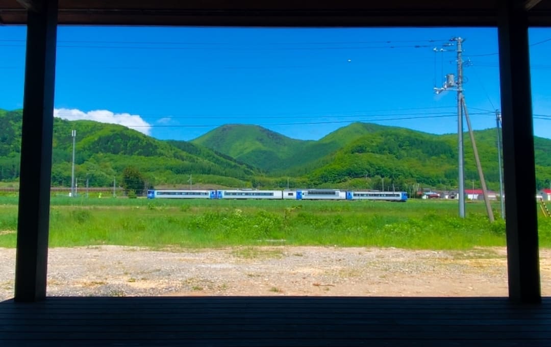 畑越しに走る石北本線の景色